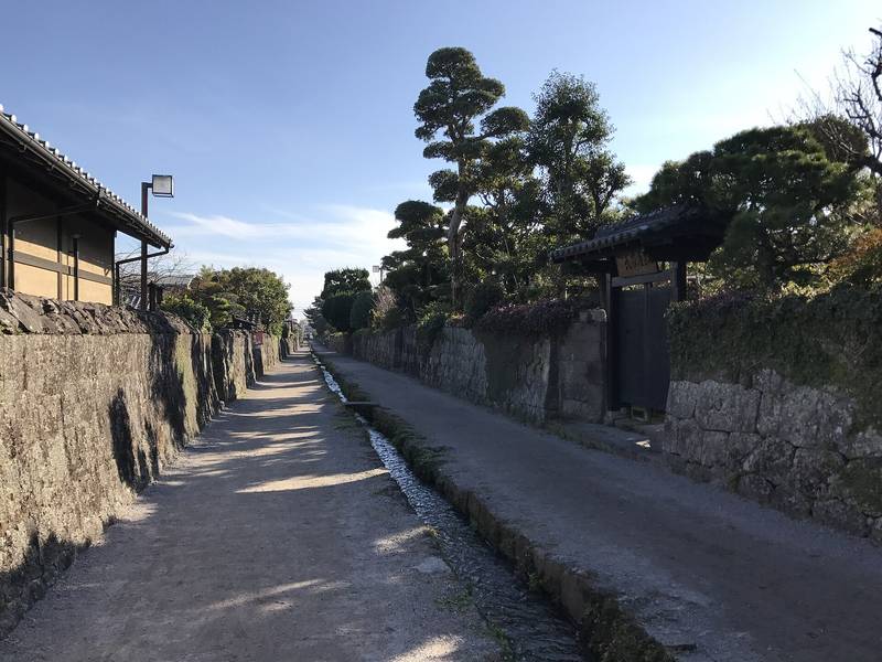 石垣に挟まれ、真ん中を水路が流れる武家屋敷街のまっすぐな道